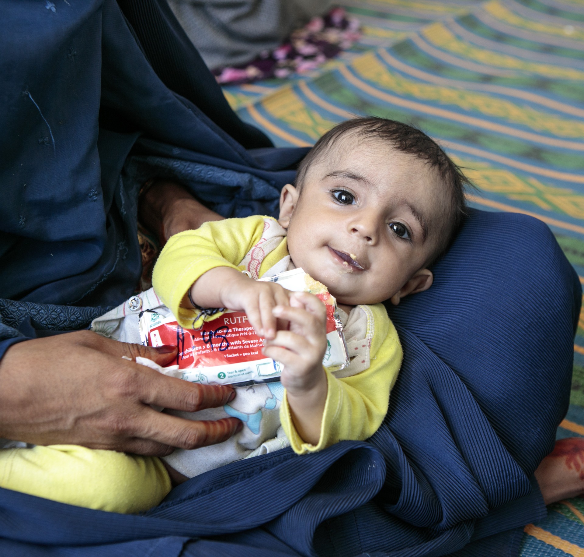 A child eats Plumpy'Nut, a peanut paste used to treat malnutrition.