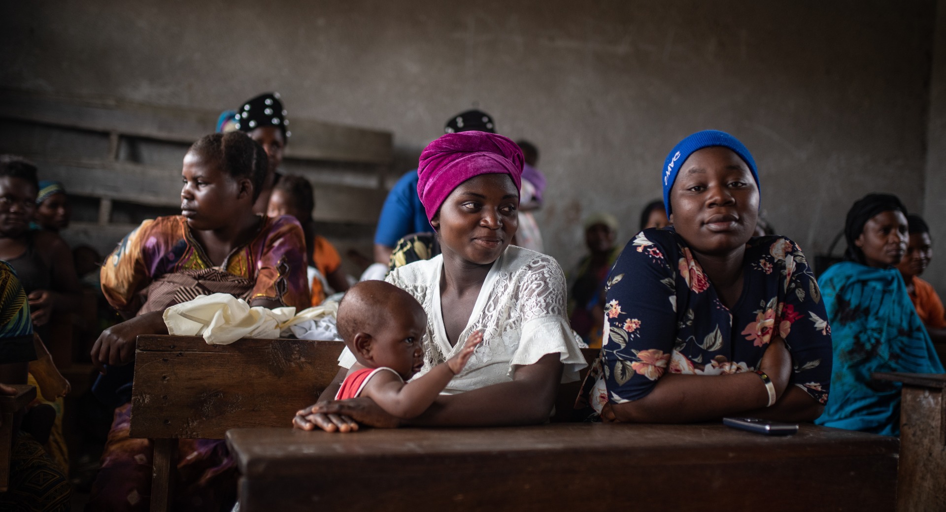 A group of women attend a mental health and care practices session at a school in Kichanga.