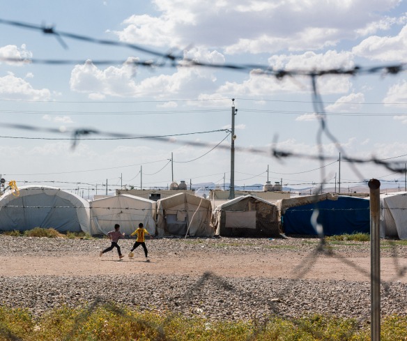 In a displacement camp in Iraq, children play soccer.