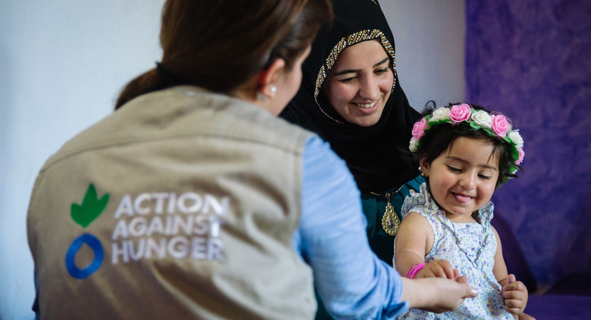 A mother and child talk with an Action Against Hunger psychosocial worker.