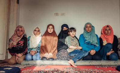 Mariam Agaghas, 47, a refugee sits in Irbid, Jordan, with her six daughters.