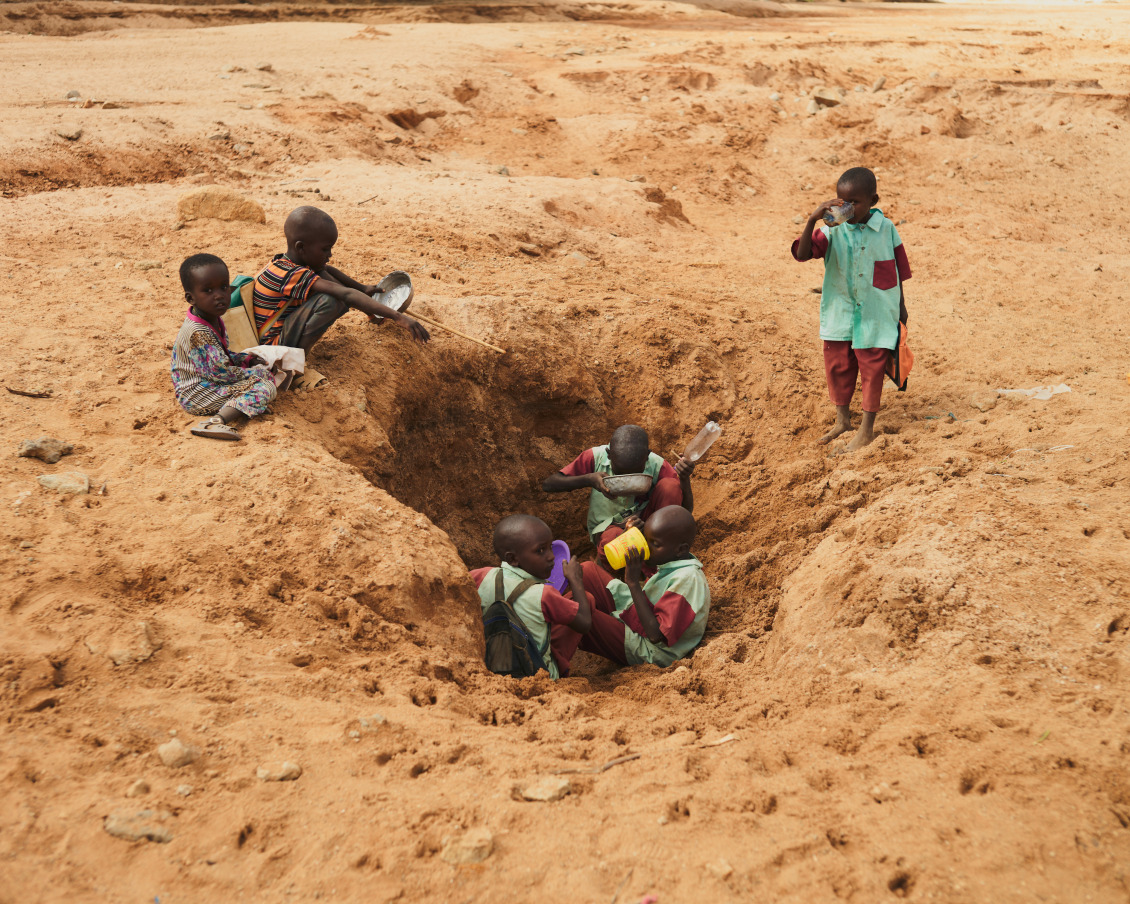 On the dry river in Laresoro, villagers dig holes to find some water, here children on their way to school stop there to drink and fill their bottles, the water has a brown color, and is full of bacteria. Children often have black spots on their teeth due to water and gastric problems.