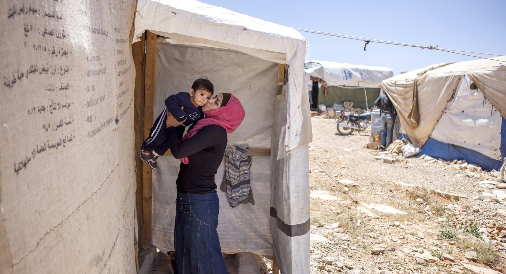 Une réfugiée syrienne embrasse son fils.