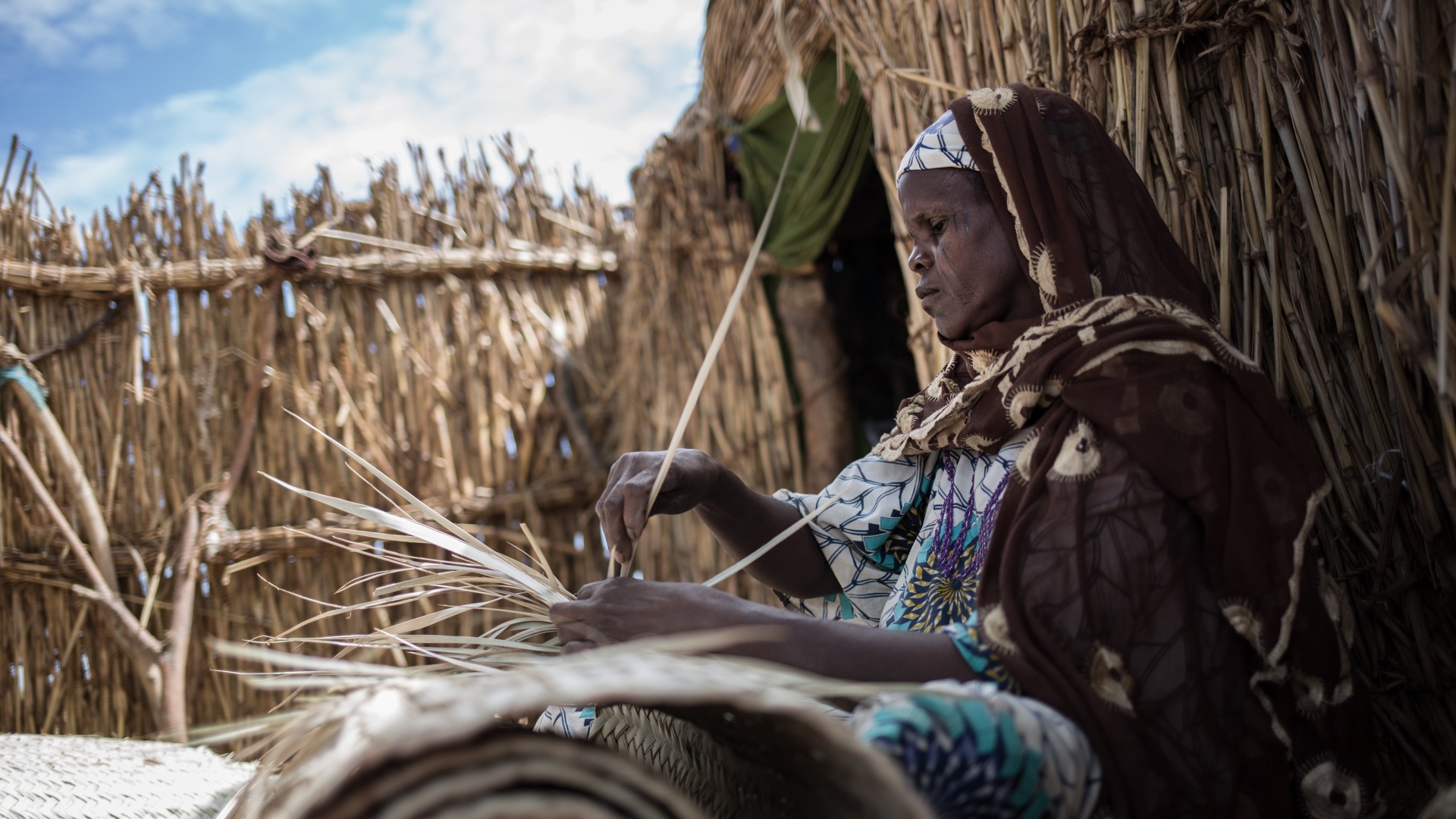 Une femme tresse des paniers au Niger.