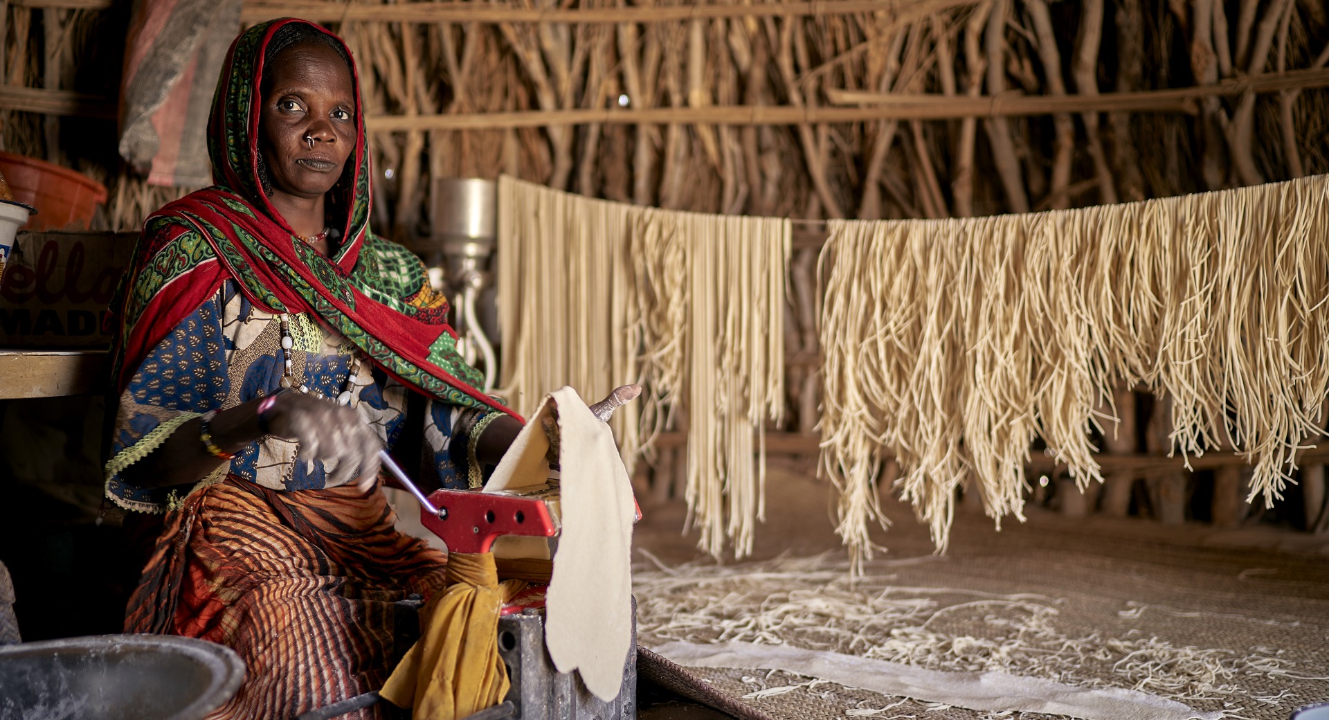 A woman makes pasta inside her home.