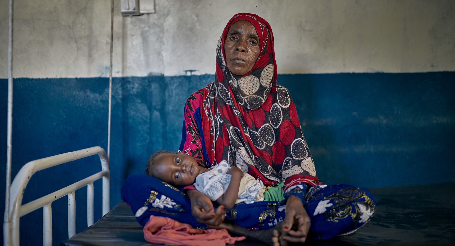 A woman holds her two year old granddaughter in her lap at an Action Against Hunger Health Center in Chad