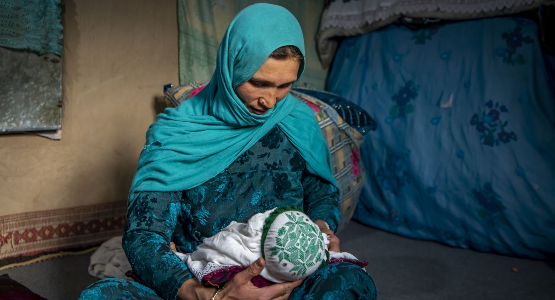 Nadia nurses her youngest child, 2 months old, at home in Duykondi Province, Afghanistan. Action Against Hunger works in this area to manage feeding programs and provide mobile health and nutrition support.