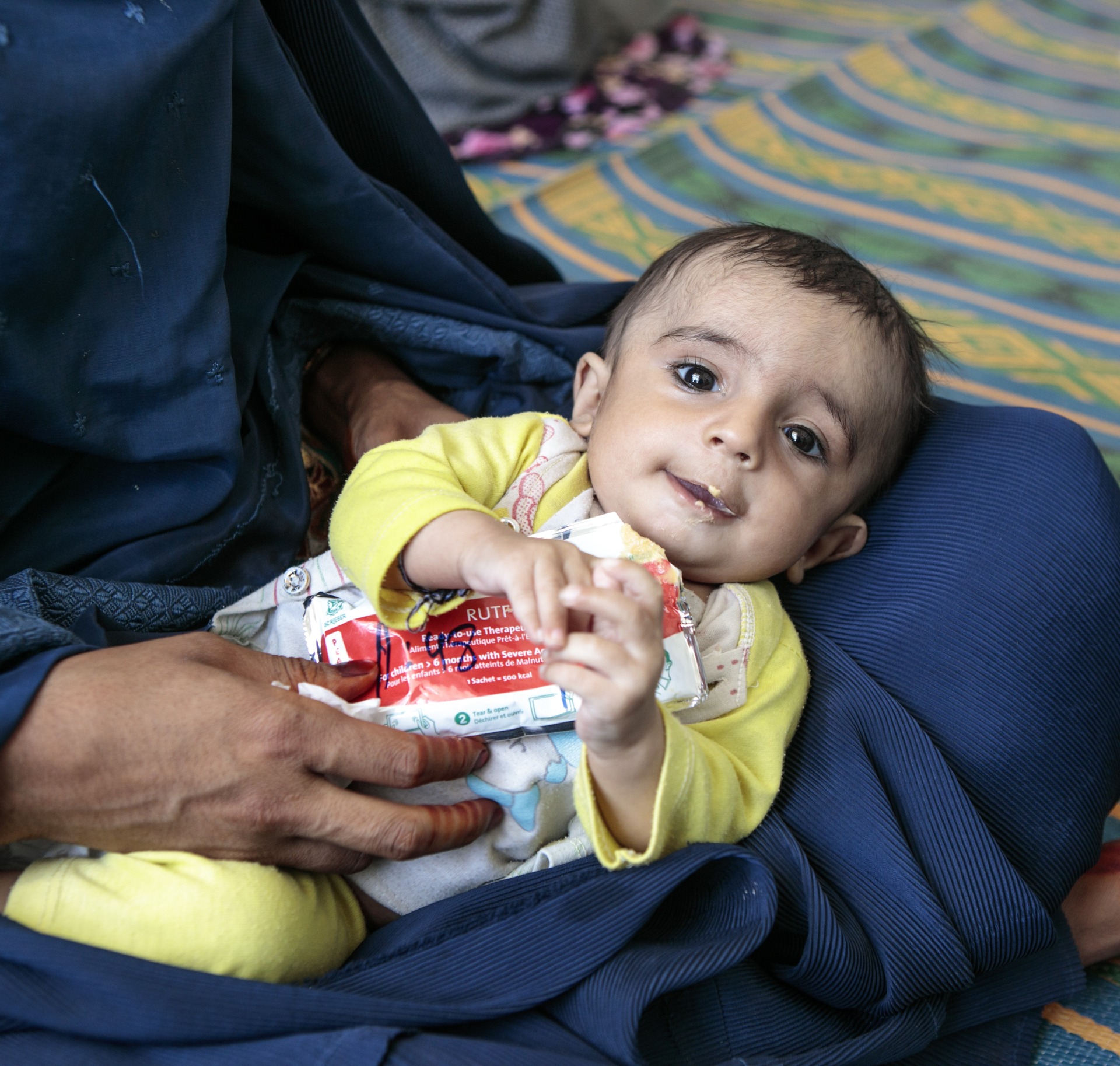 A child eats Plumpy'Nut, a peanut paste used to treat malnutrition.