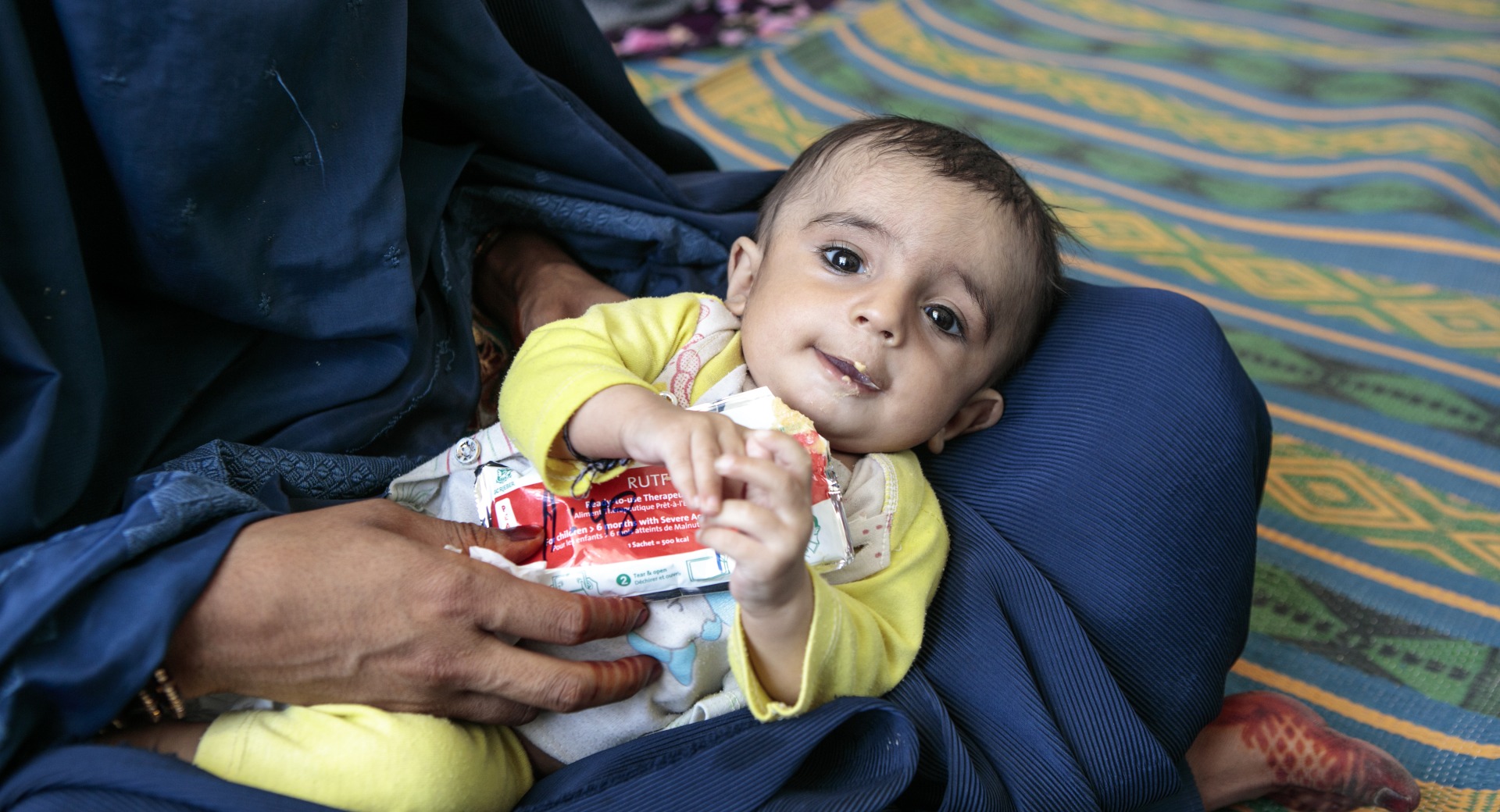 A child eats Plumpy'Nut, a peanut paste used to treat malnutrition.