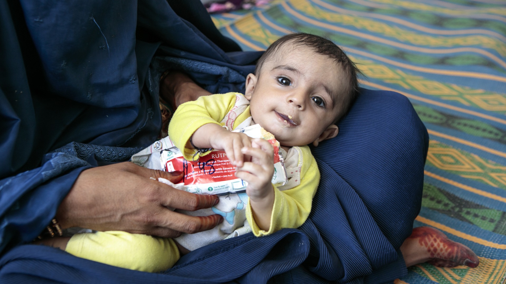 A child eats Plumpy'Nut, a peanut paste used to treat malnutrition.