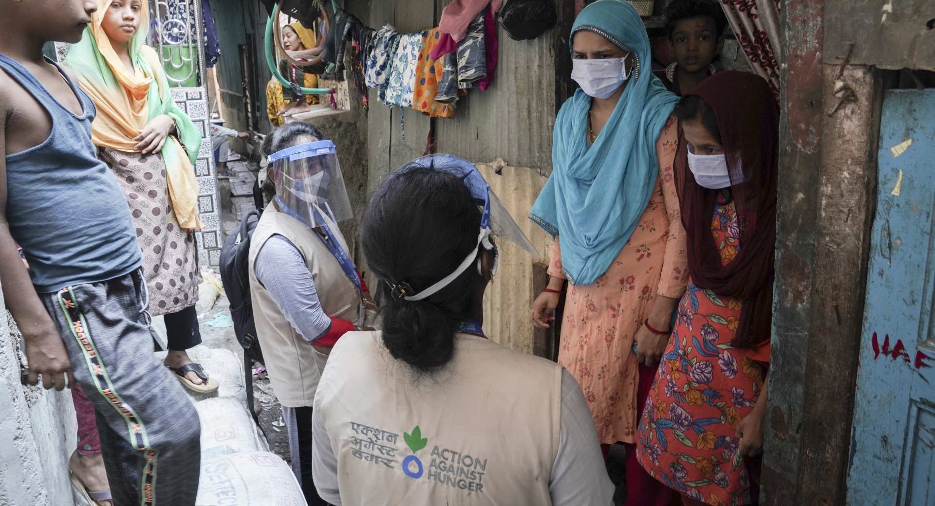 Action Against Hunger Community Mobilizers Kavita and Janhvi visit Anjum at home, following up on the supplies and advice they've provided.