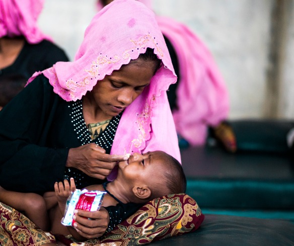 A mother gives her baby Plumpy'Nut to treat malnutrition at an Action Against Hunger nutrition center.