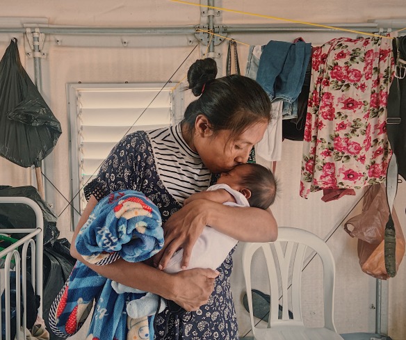 Une mère embrasse son bébé. Sa famille a été déplacée par le conflit et reçoit maintenant une aide financière d'Action contre la faim.