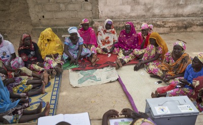 A meeting of a women's savings and loans association, where women learn to pool their resources and save for emergencies and investments.