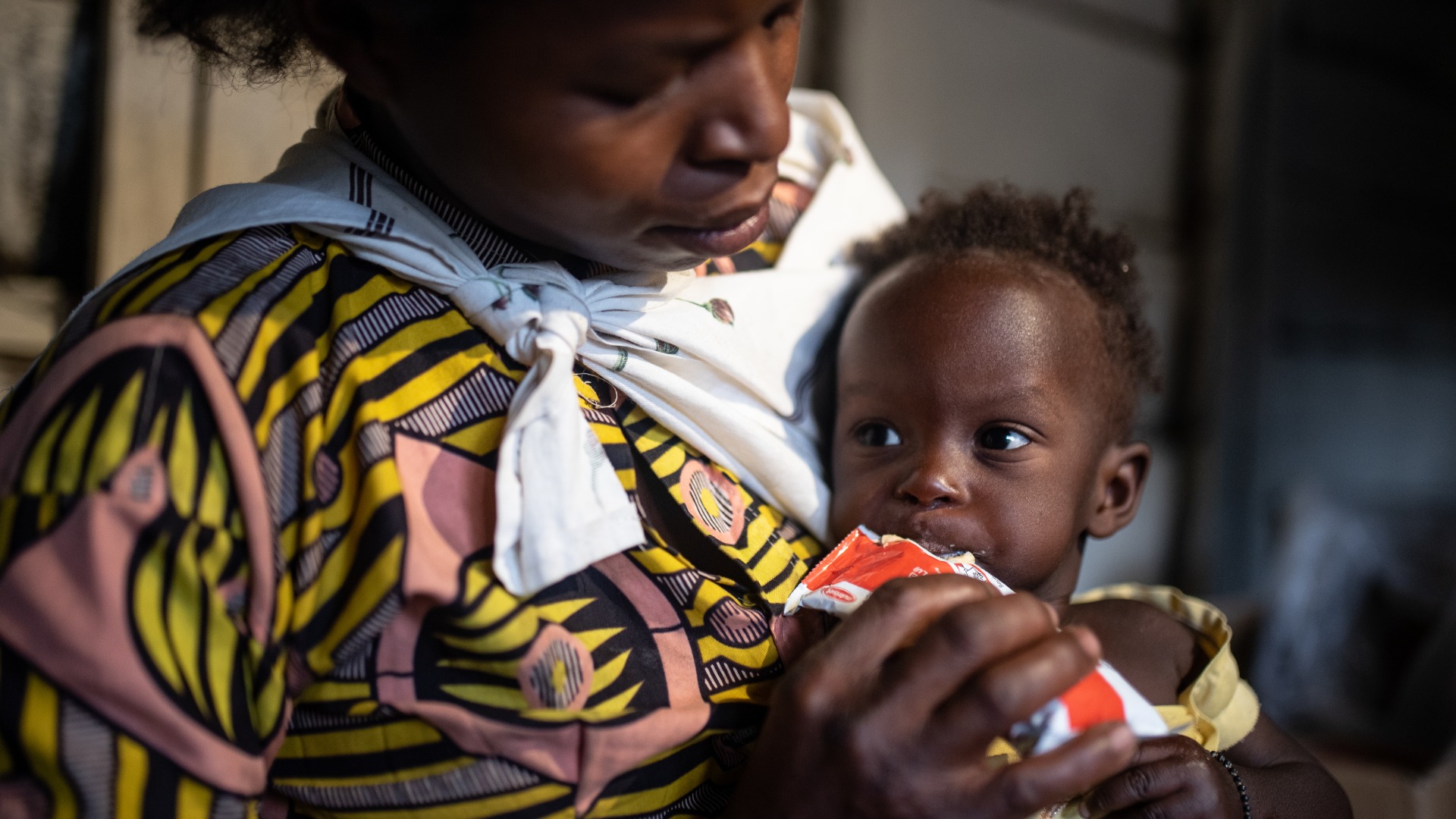 A mother feeds her child Plumpy'Nut, the peanut paste used to treat malnutrition.