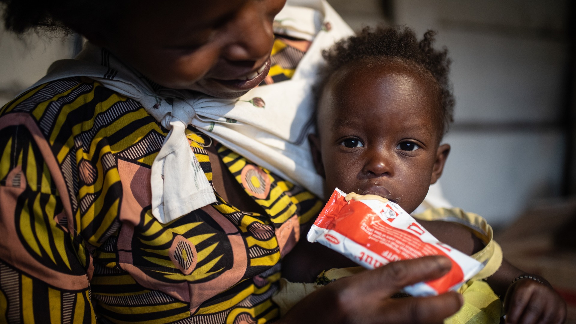 A mother feeds her child Plumpy'Nut, the peanut paste used to treat malnutrition.