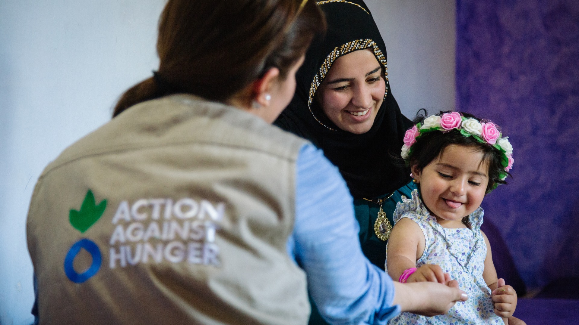 A mother and child talk with an Action Against Hunger psychosocial worker.