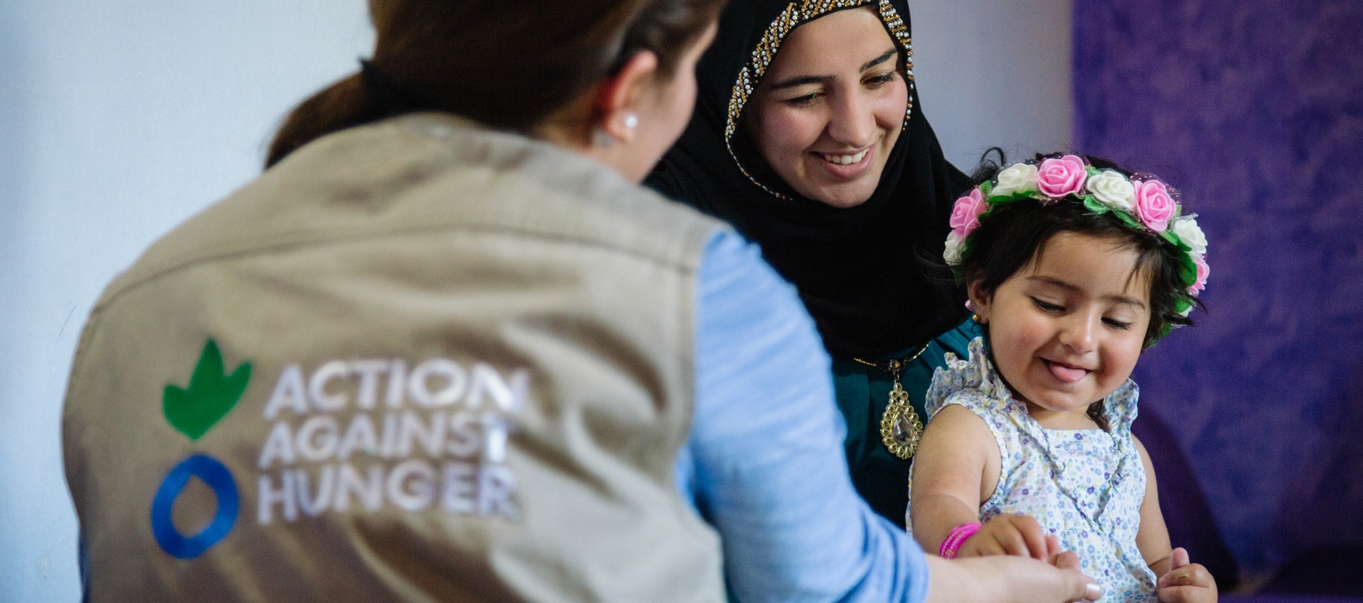 A mother and child talk with an Action Against Hunger psychosocial worker.