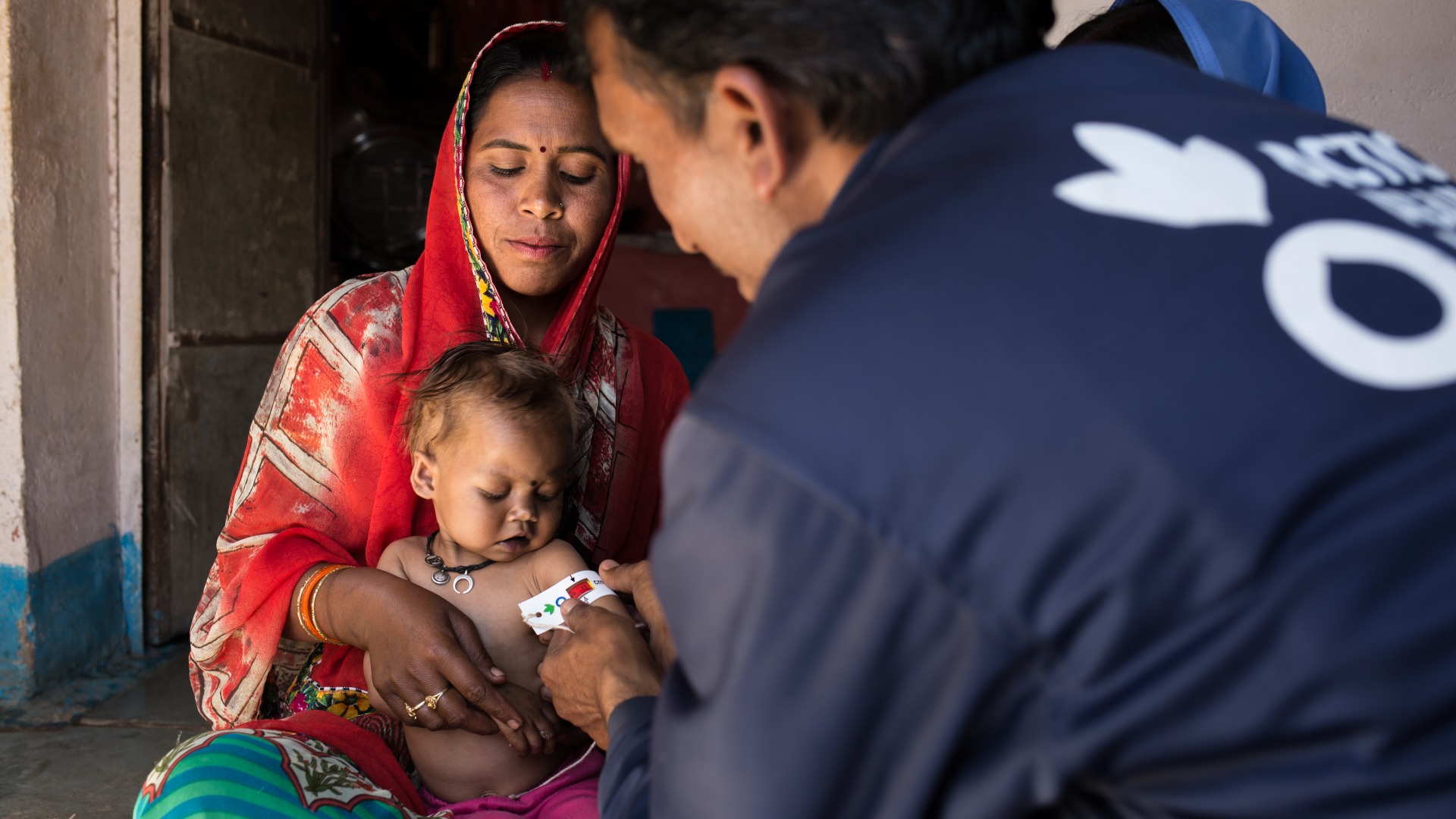 Community Health Worker Balram measures the mid-upper arm circumference of a three-year-old girl named Bhumika, and finds that she is severely malnourished.