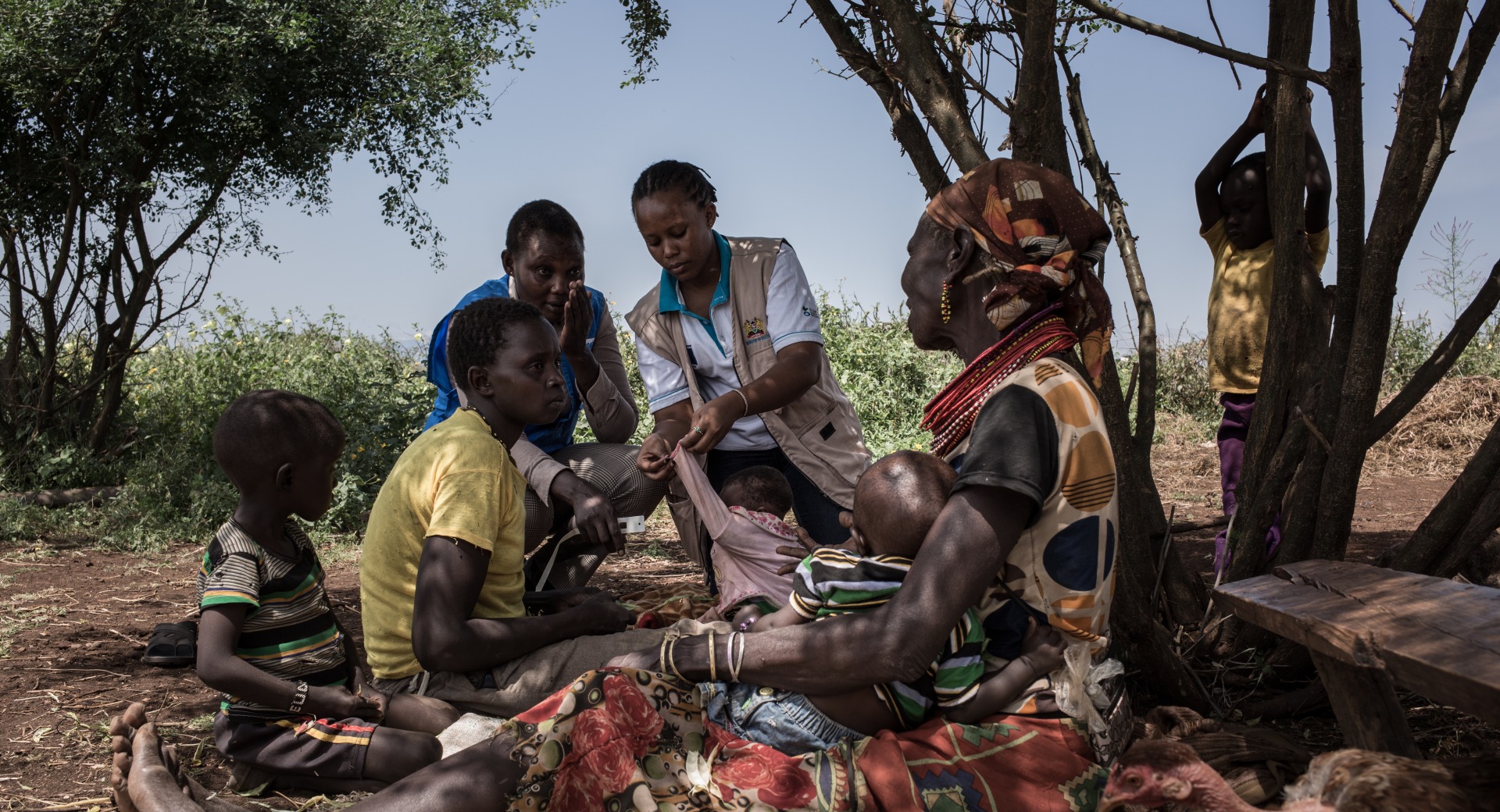 Magdalena, volontaire en santé communautaire, examine deux enfants de la tribu Turkana. L'un d'eux souffre de malnutrition et fait l'objet d'un traitement et d'un suivi.