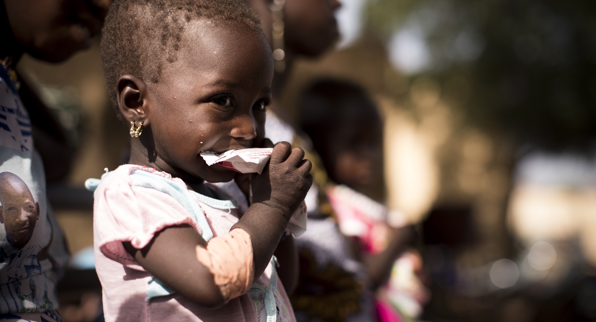 A girl eats Plumpy'Nut, the lifesaving ready-to-use therapeutic food that will help her recover from malnutrition.