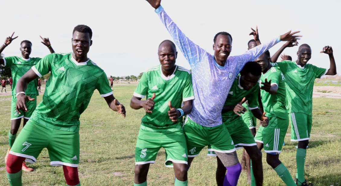 Players run to the camera in celebration after the Puyoy team scores the opening goal in the final tournament game.