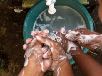 Children wash their soapy hands.