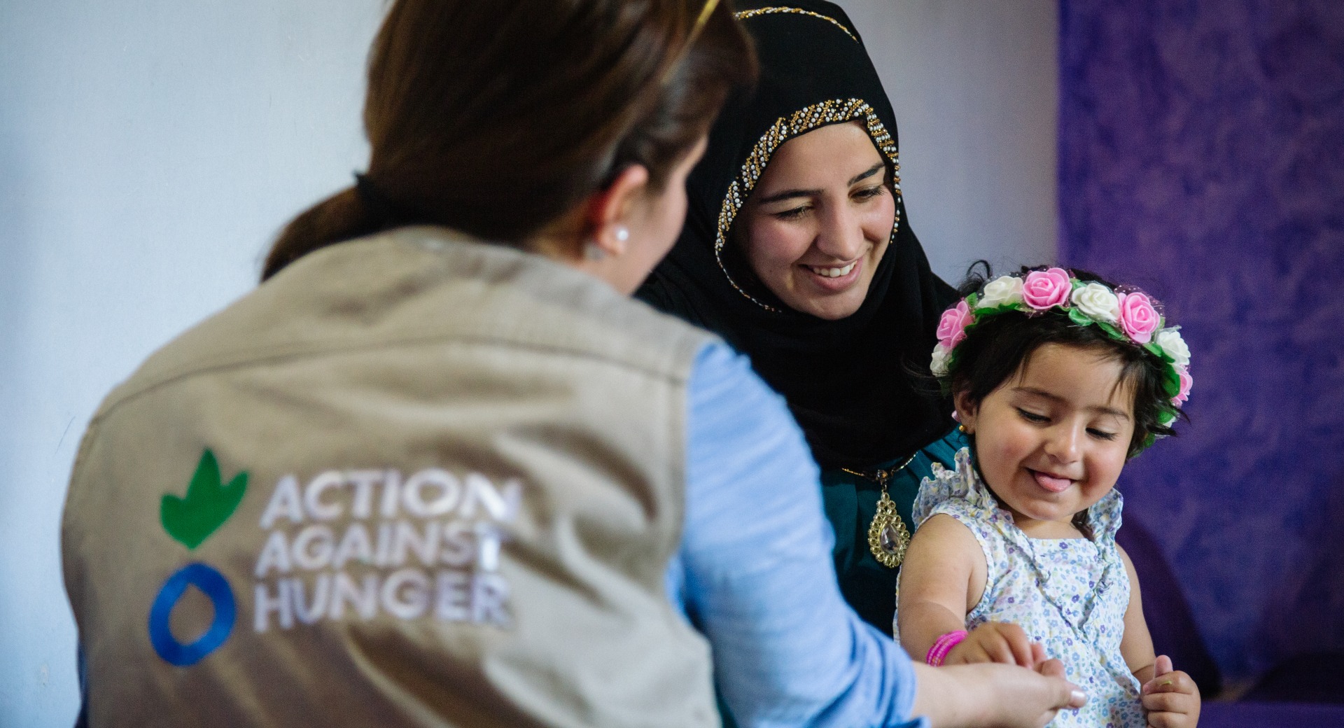 A mother and child talk with an Action Against Hunger psychosocial worker.