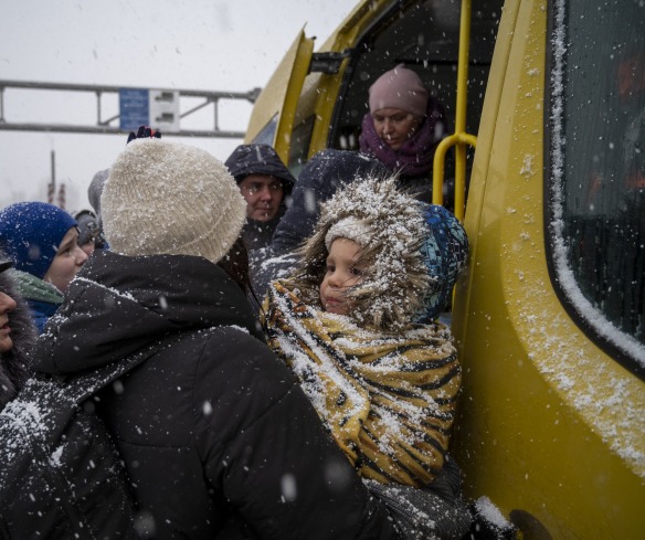 Ukrainian refugees face winter weather as they board a bus and cross the border into Moldova.