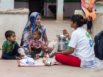 An Action Against Hunger Community Mobilizer visits with a family at their home.